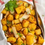 This is a square picture of a dish filled with air fryer potatoes and onions.