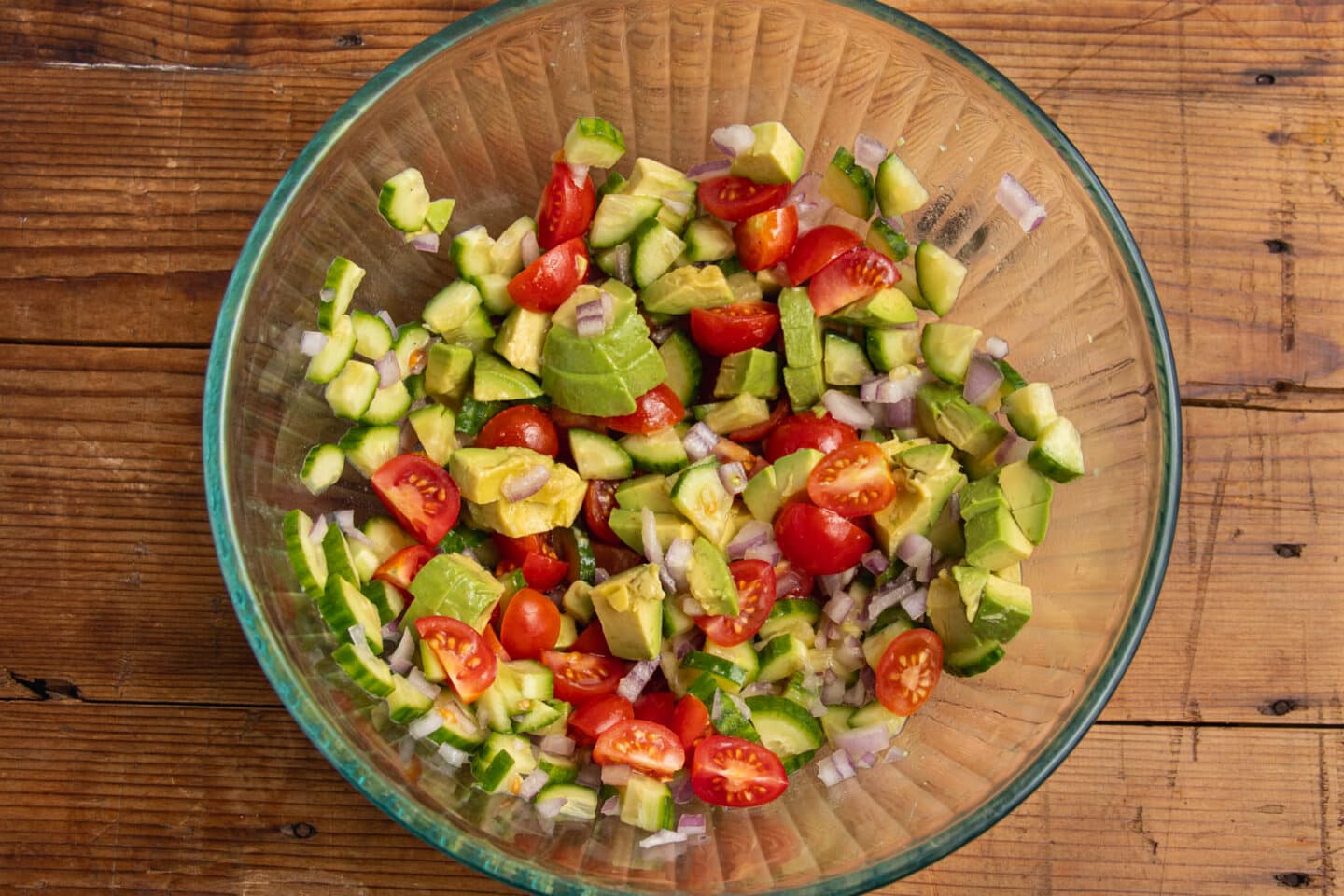 This is a picture of the cucumber, tomatoes, avocado and onion tossed with dressing.