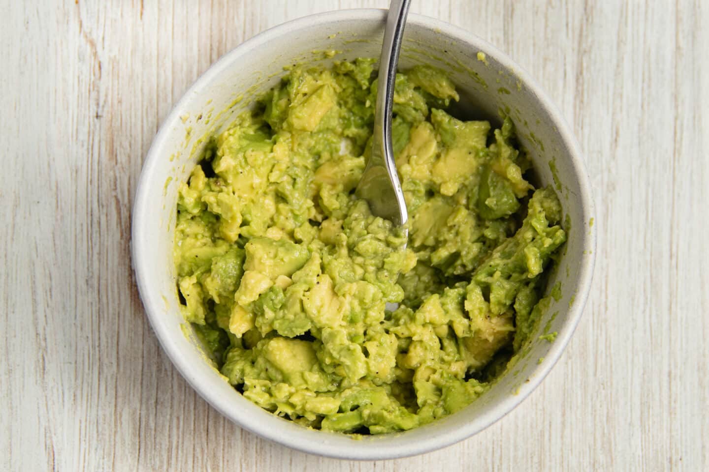 This is a picture of a bowl with smashed avocado.