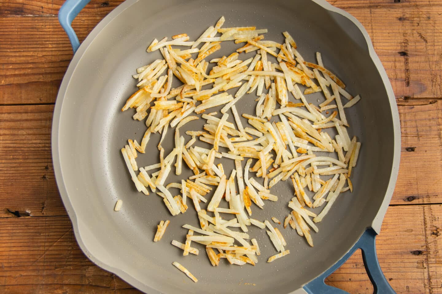 This is a picture of the hashbrowns getting cooked in a skillet.