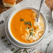 This is a square picture of a bowl of roasted tomato butternut squash soup.