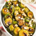 This is a square picture of a bowl of Brussels sprouts with feta and balsamic glaze.