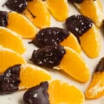 This is a square picture of oranges dipped in chocolate.
