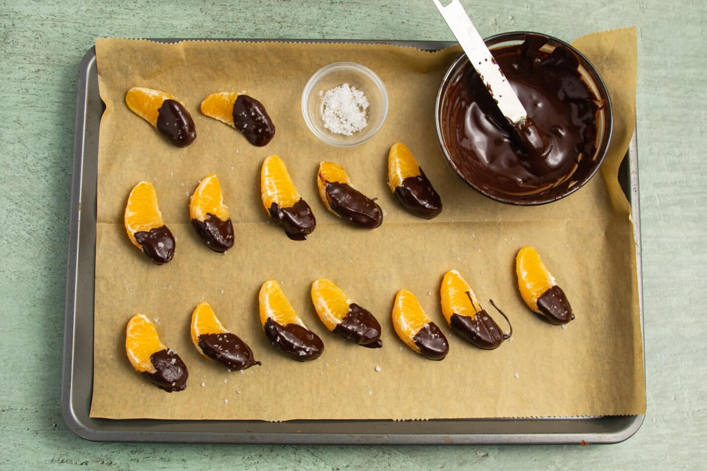 This is a picture of the oranges dipped and resting on parchment paper.