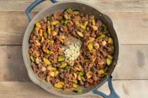 This is a picture of ground beef & veggies with added garlic cooking in a skillet.
