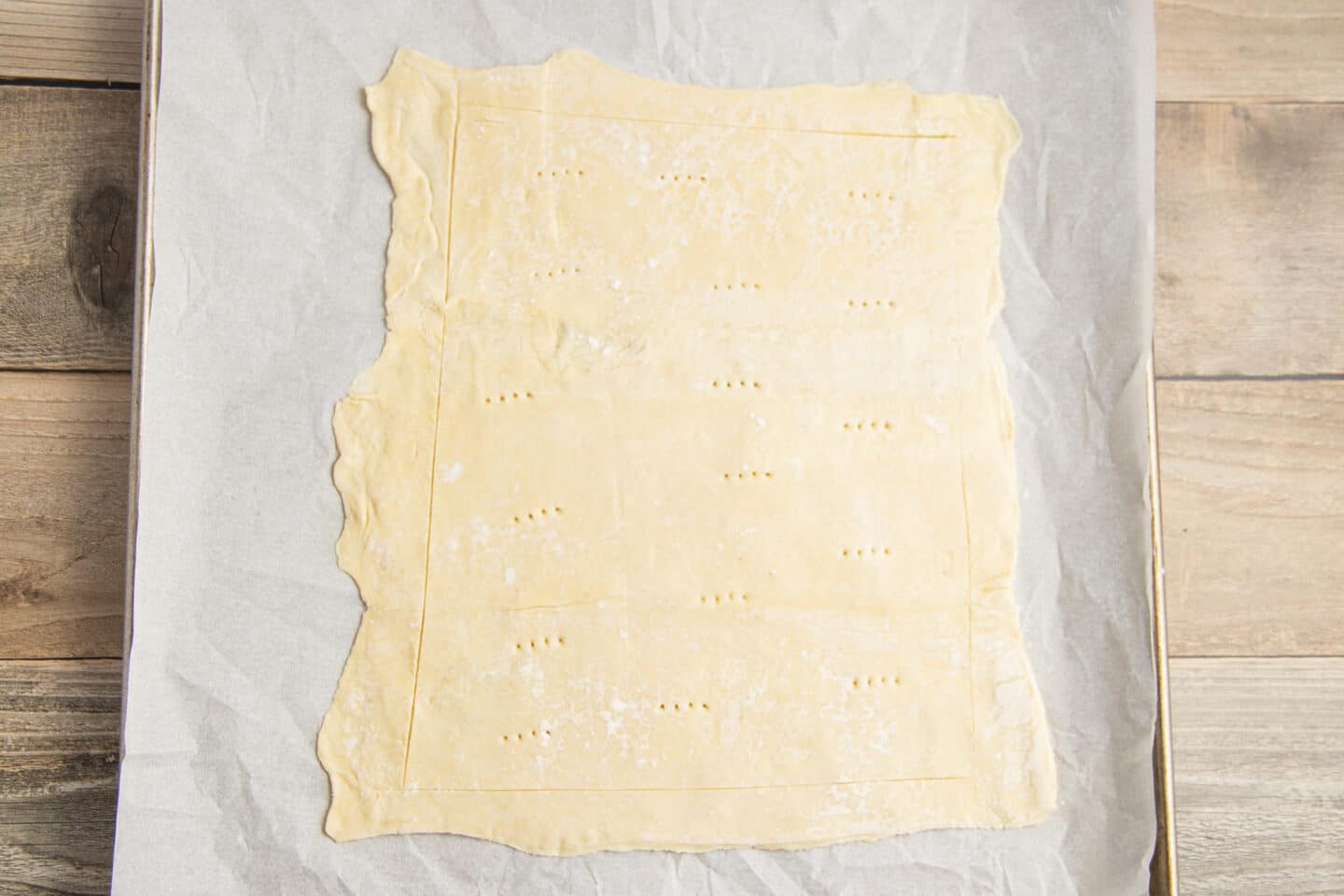 This is a picture of a puff pastry rolled on a baking sheet.