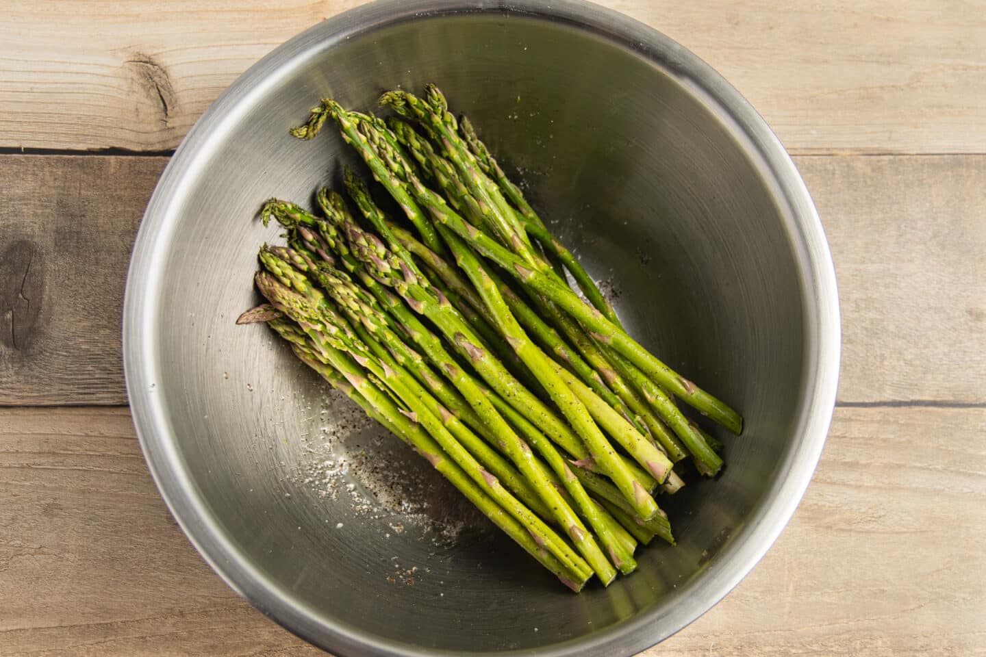 This is a picture of a bowl with seasoned asparagus.