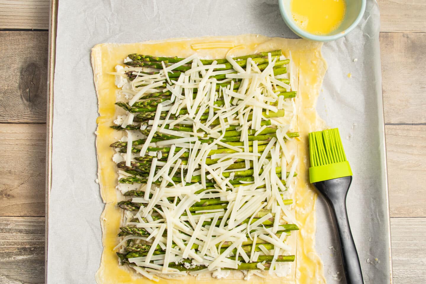 This is a picture of the puff pastry with asparagus, cheese and egg wash around.