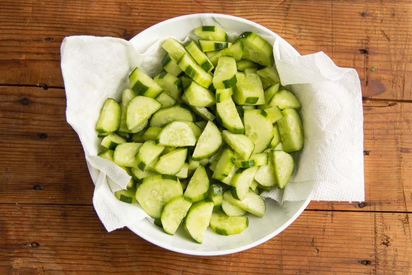 This is a picture of cucumber in a bowl lined with papder towels.