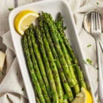 This is a picture of a dish filled with grilled asparagus.