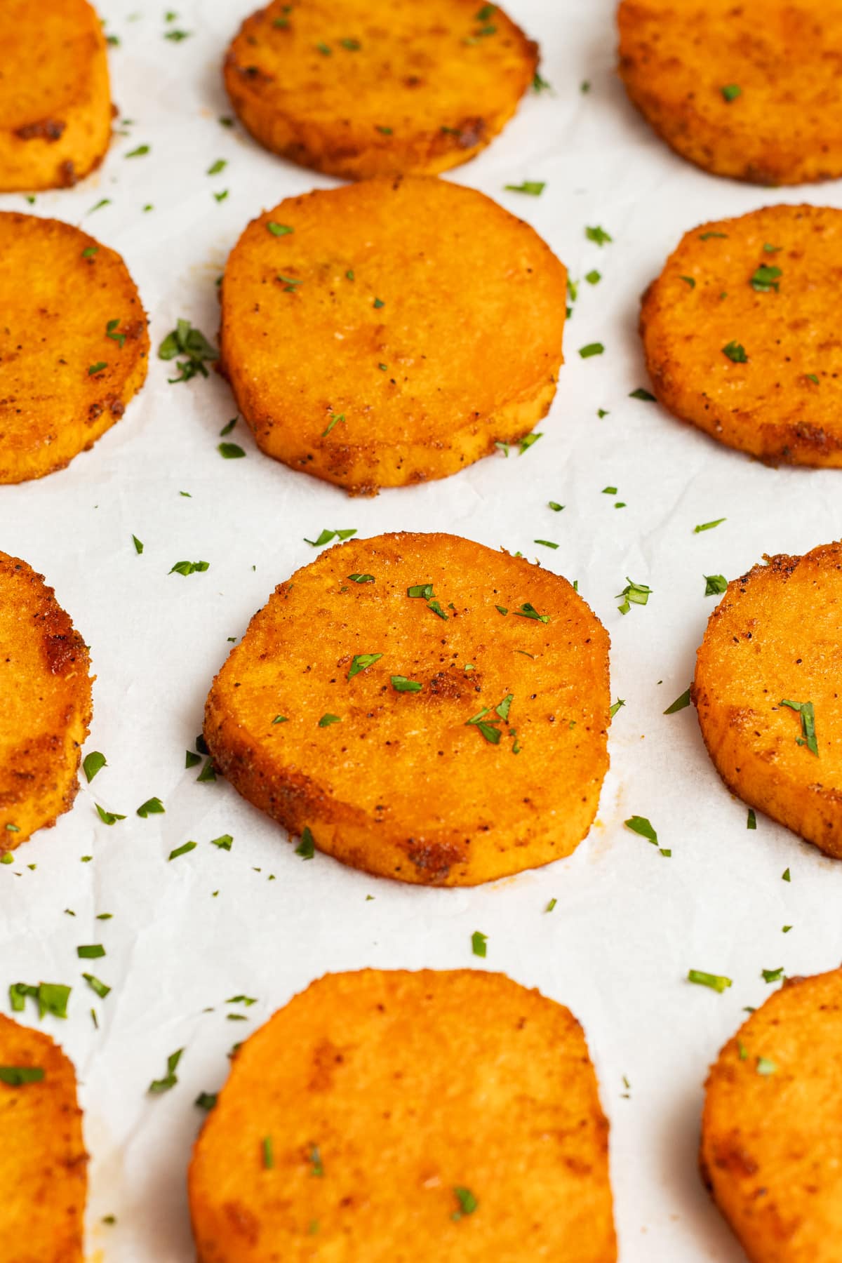 This is a picture of a sheet of roasted sliced sweet potato slices.