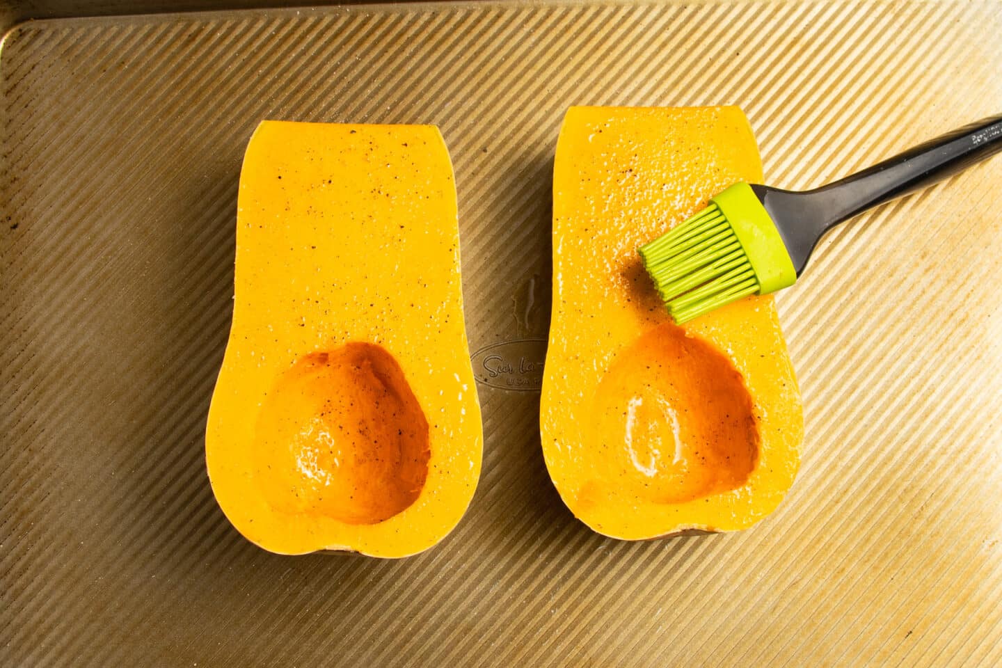This is a picture of butternut squash being brushed with oil.