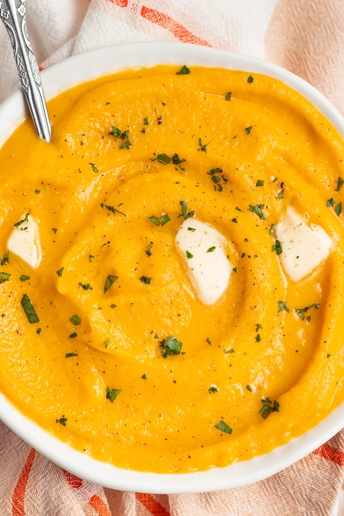 This is a bowl of mashed butternut squash with butter on top.
