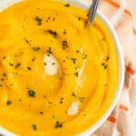 This is a bowl of mashed butternut squash with butter on top.