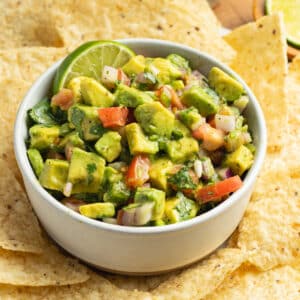 This is a picture of a bowl of avocado pico de gallo salsa.