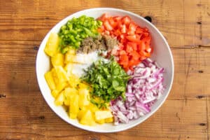 This is a picture of the ingredients chopped up in a bowl to make this pineapple salsa.