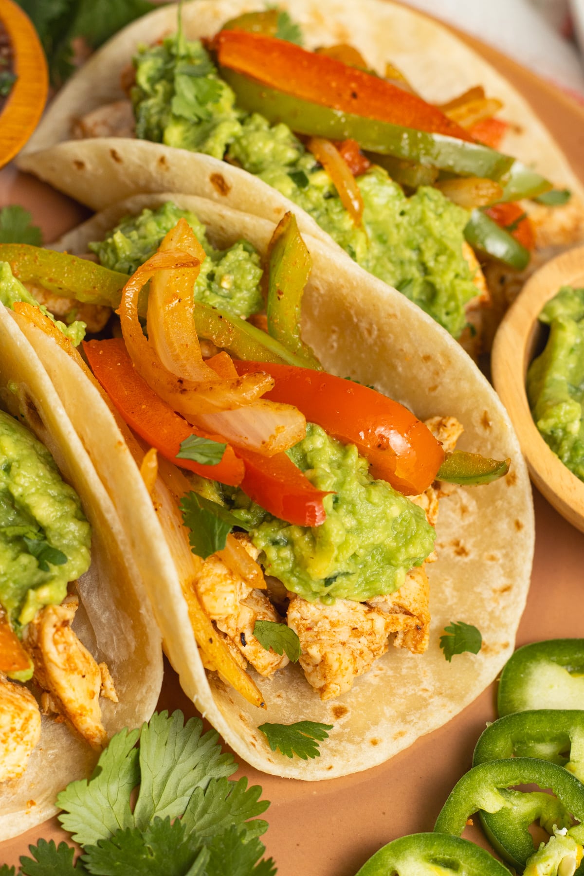 This is a picture of a chicken fajita taco close up on a plate.