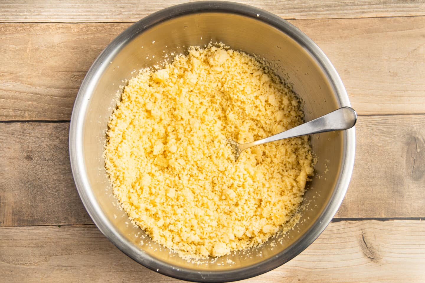 This is a picture of the couscous getting fluffed with a fork in a bowl.