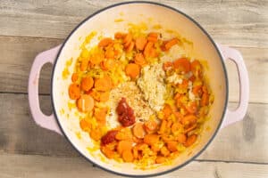 This is a picture of a pot with carrots, leeks, tomato paste and garlic added.